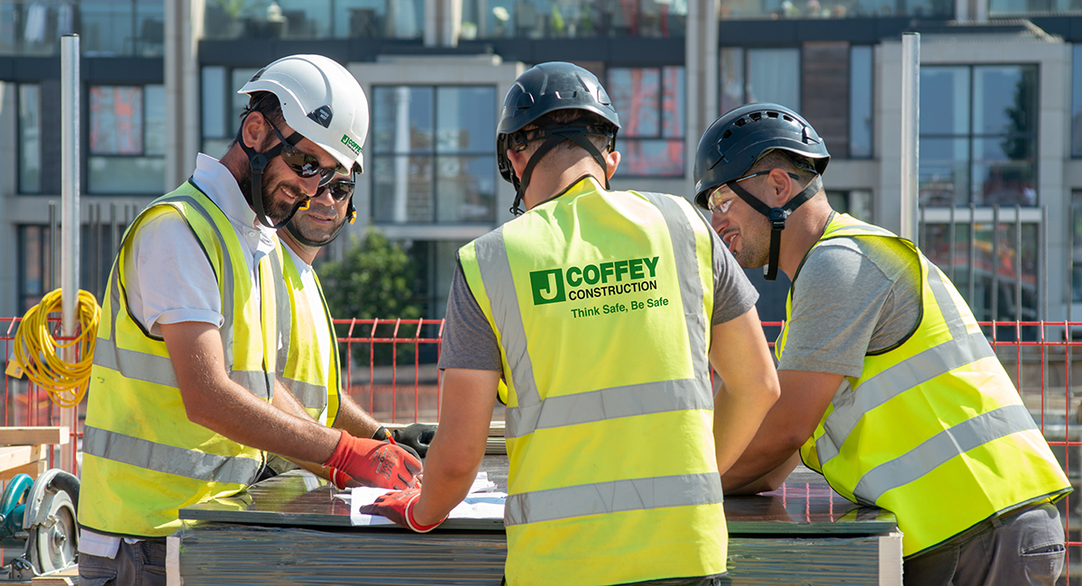 J Coffey construction workers examining project information on site