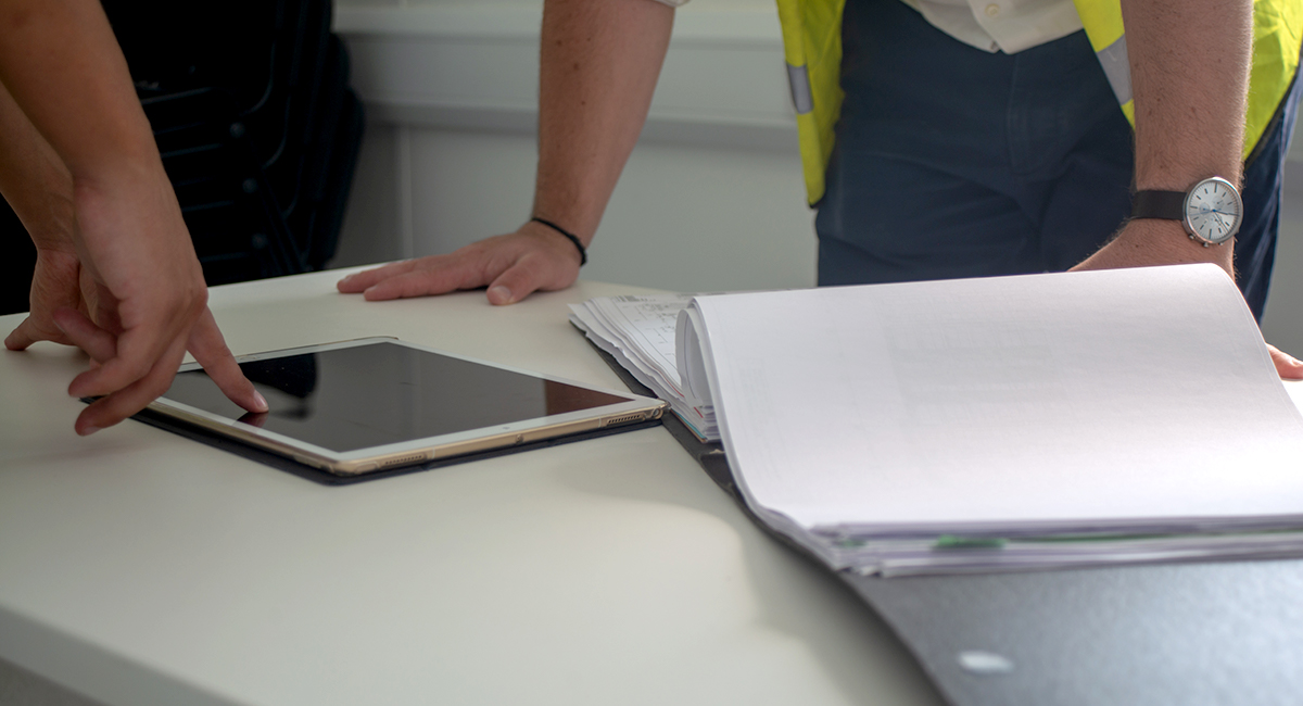 Construction workers examining a project information on a tablet